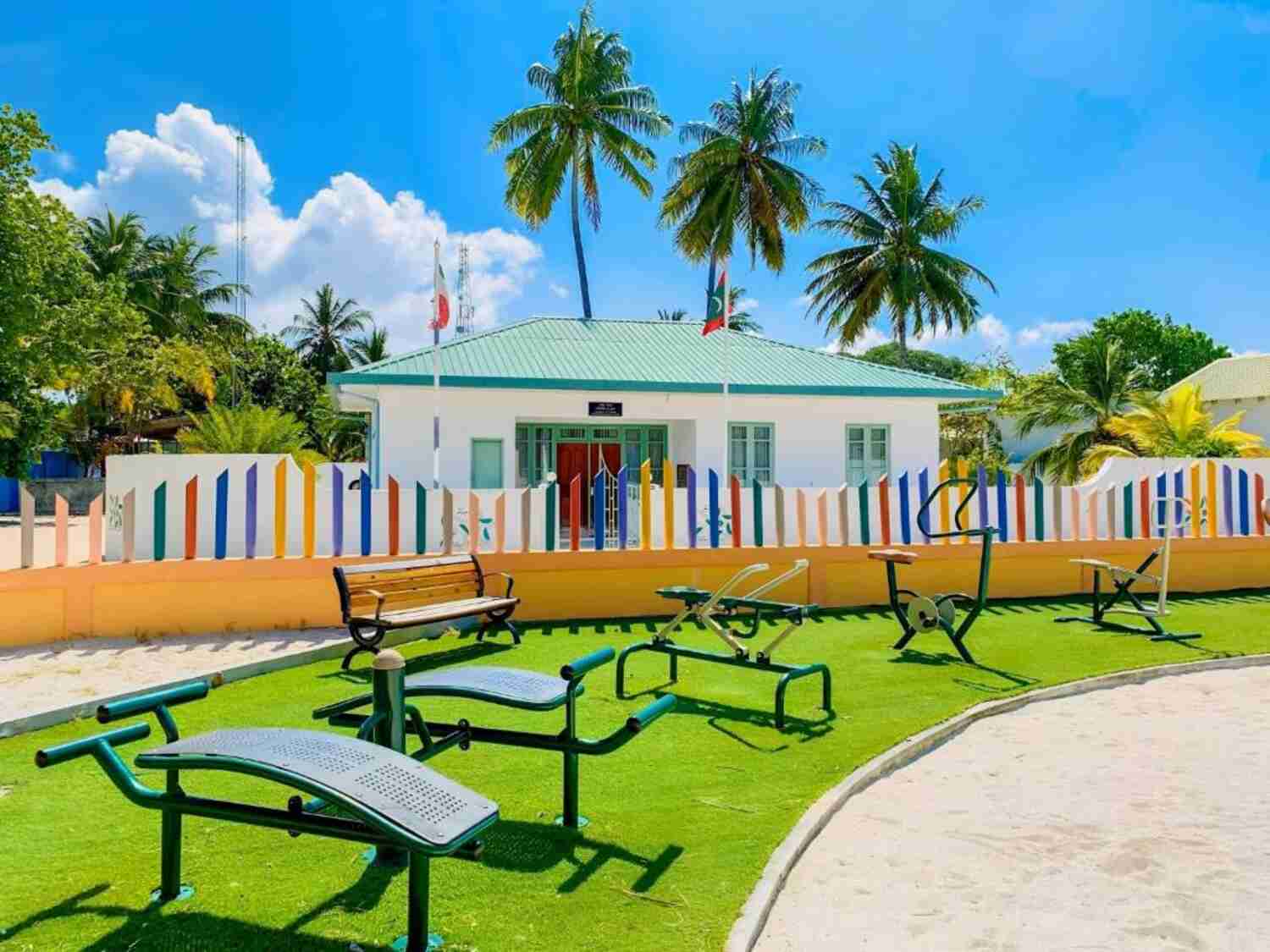Mathiveri island square with palm trees and colourful fence